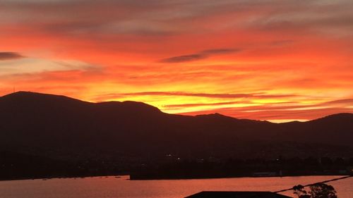 Scenic view of silhouette mountains against romantic sky at sunset