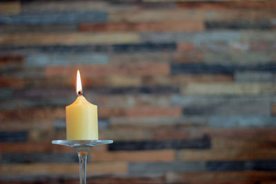 Close-up of lit candles on table against illuminated building