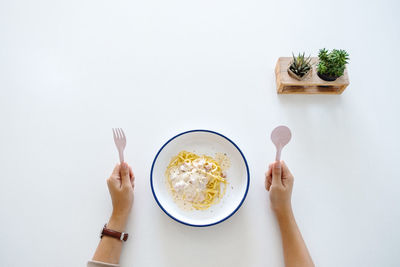 Directly above shot of woman holding ice cream against white background