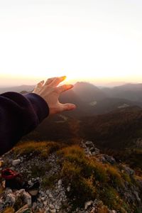 Person on rock against sky