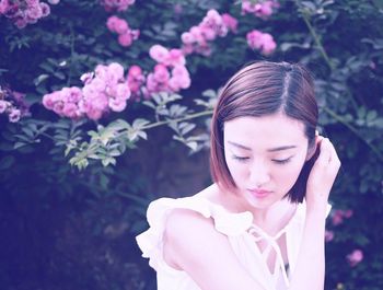 Portrait of woman holding pink flower