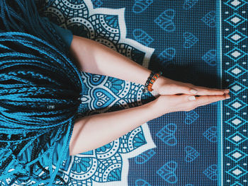 High angle view of woman praying on carpet at home