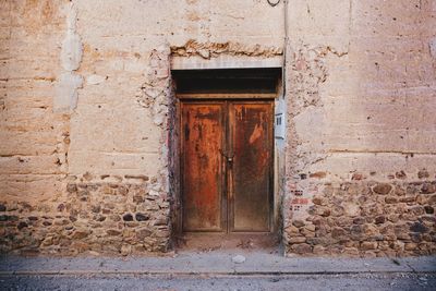 Door of an old adobe house in the village llamas de la ribera, rural león. spain