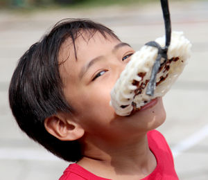 Close-up portrait of boy participating in crack feeding competition