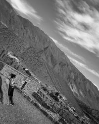 Midsection of woman standing on mountain against sky