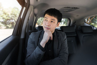 Portrait of young man sitting in car