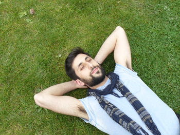 High angle view of man lying on grassy field
