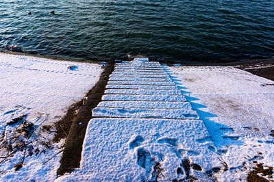 Snowcapped stairs going down to the lake shore in bucharest, romania