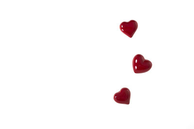 Close-up of red heart shape over white background