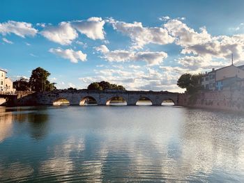 Arch bridge over river against sky