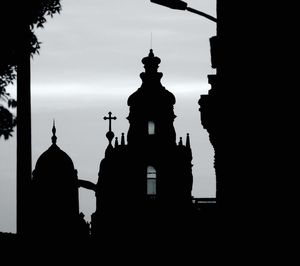 Low angle view of silhouette temple against building