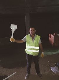 Full length portrait of young man standing against wall