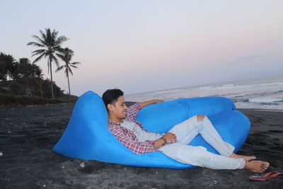 Rear view of woman sitting on beach