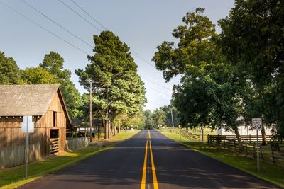 Road amidst trees against sky