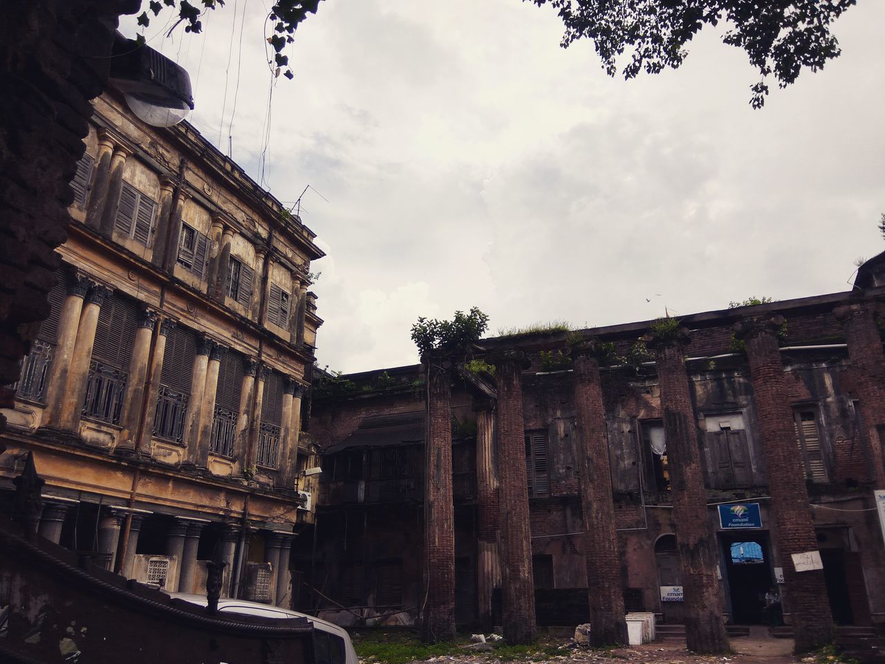 architecture, built structure, building exterior, low angle view, sky, window, cloud - sky, outdoors, obsolete, day, history, cloudy, no people, facade, architectural feature, weathered, historic building