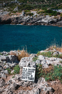 Information sign on rock by sea