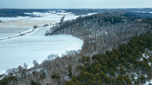 Snow covers the hills and fields with farm fields between the slopes.