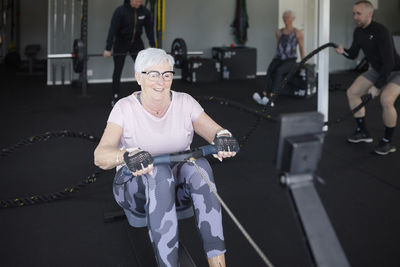 Smiling senior woman exercising in gym