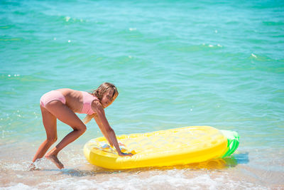 Rear view of woman swimming in sea