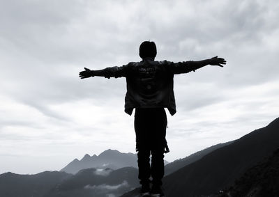 Rear view of silhouette man standing against sky