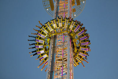 Low angle view of ferris wheel against clear blue sky