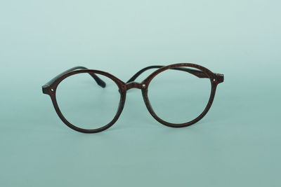 Close-up of eyeglasses on table against blue background
