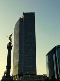 Statue in city against clear sky