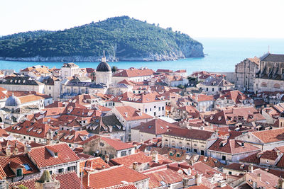 High angle view of townscape by sea against sky