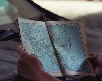 Close-up of cropped hand holding book