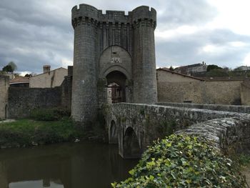 Historic castle by river against sky