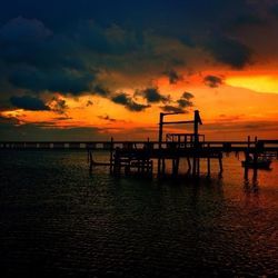 Pier on sea at sunset
