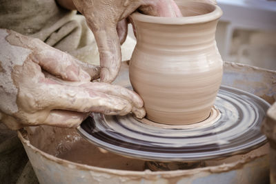 Midsection of person working on potters wheel