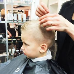 Person cutting hair of boy