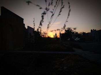 Silhouette cityscape against sky during sunset