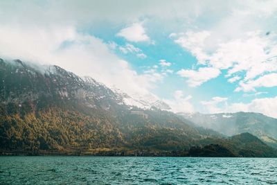 Scenic view of lake by mountains against sky