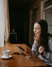 Young woman using mobile phone at home