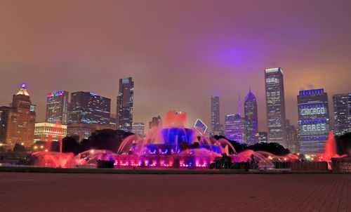 Illuminated buildings against sky at night