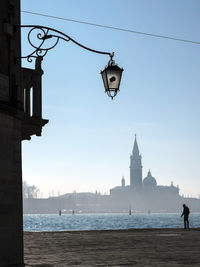 Lamp post at beach against clear sky