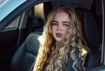 Portrait of young woman in car