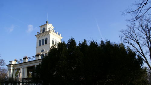 Low angle view of trees and building against sky