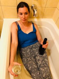 High angle view portrait of woman using mobile phone in bathroom