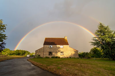 View of a full rainbow over the top of a house