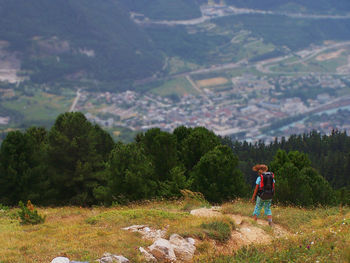 Rear view of woman standing on mountain landscape