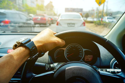 Close-up of hand driving car