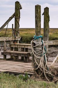 Rope tied on wooden post in field