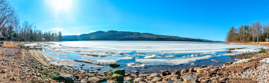 Scenic view of lake against clear blue sky during winter