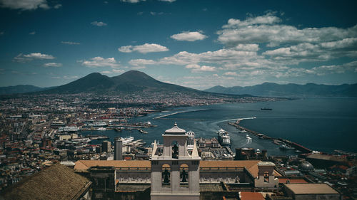 High angle view of townscape by sea against sky