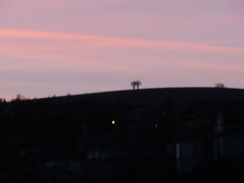 Silhouette landscape against orange sky