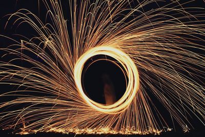 Person spinning wire wool at night