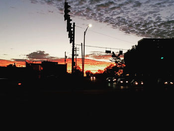 Silhouette city against sky at sunset